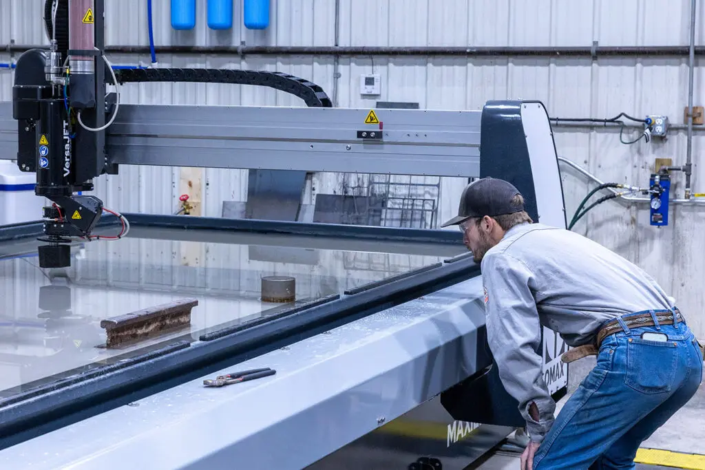 Elite Fabz Technician inspecting material before waterjet cutting