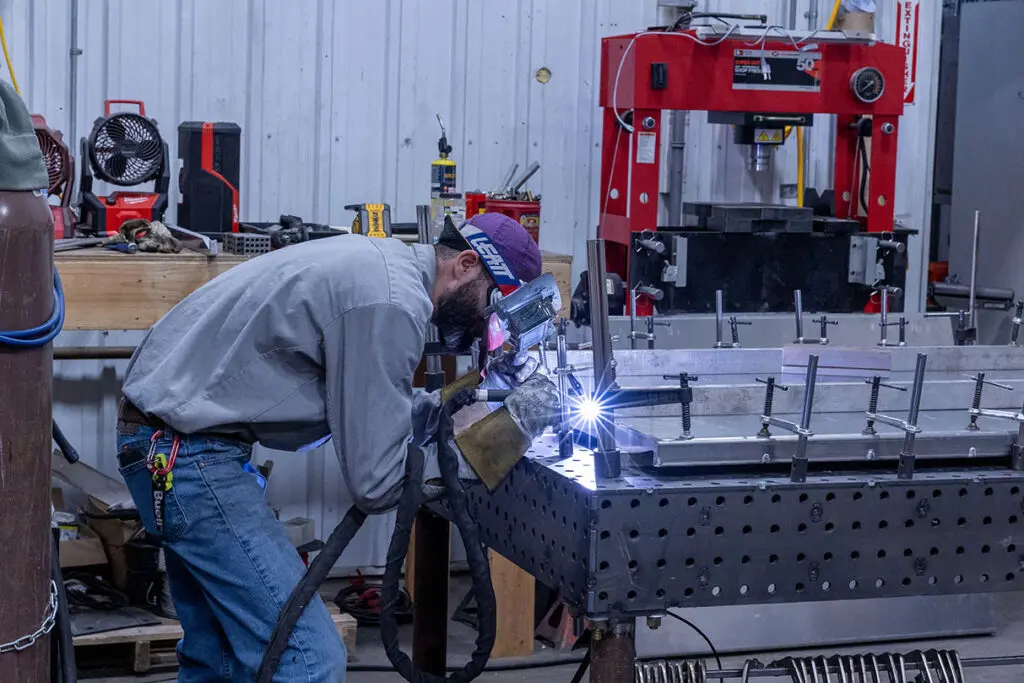 Elite Fabz Technician using a Mig Welder to fuse pieces on a project